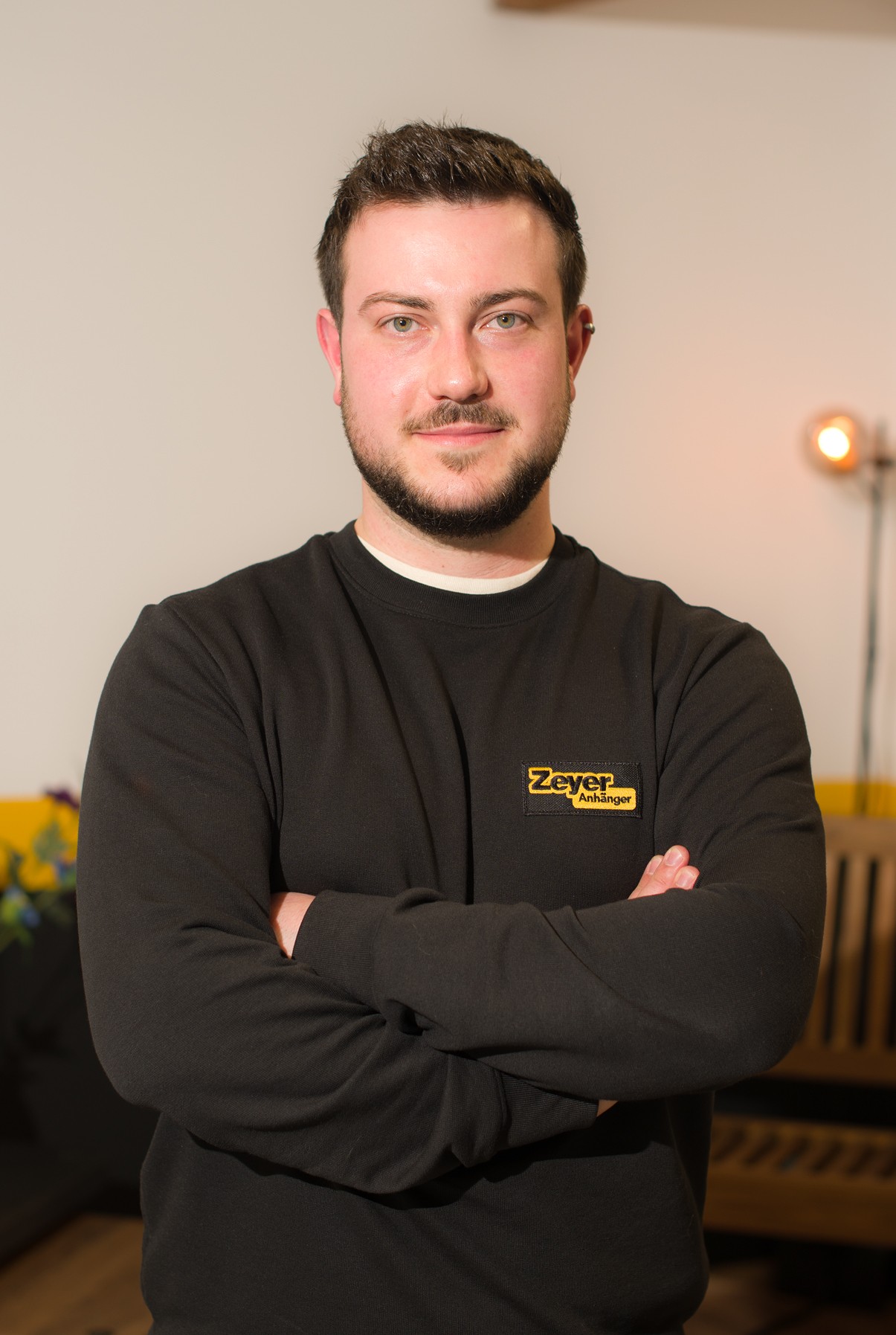 Mann in schwarzem Pullover mit verschränkten Armen