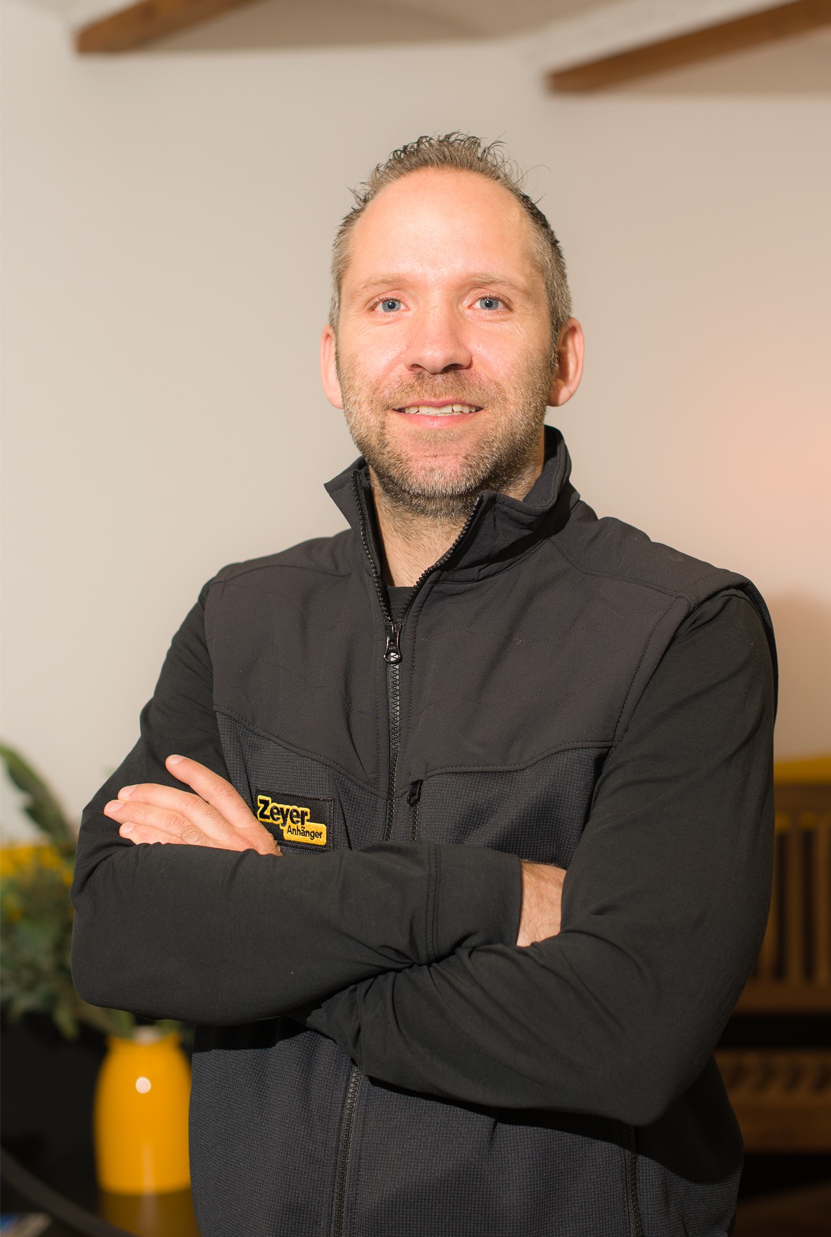 Mann in schwarzer Jacke lächelt.