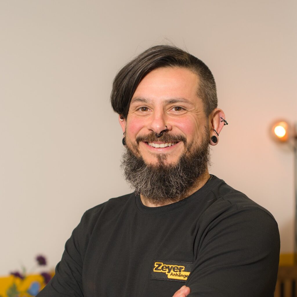 Lächelnder Mann mit Bart und Schmuck