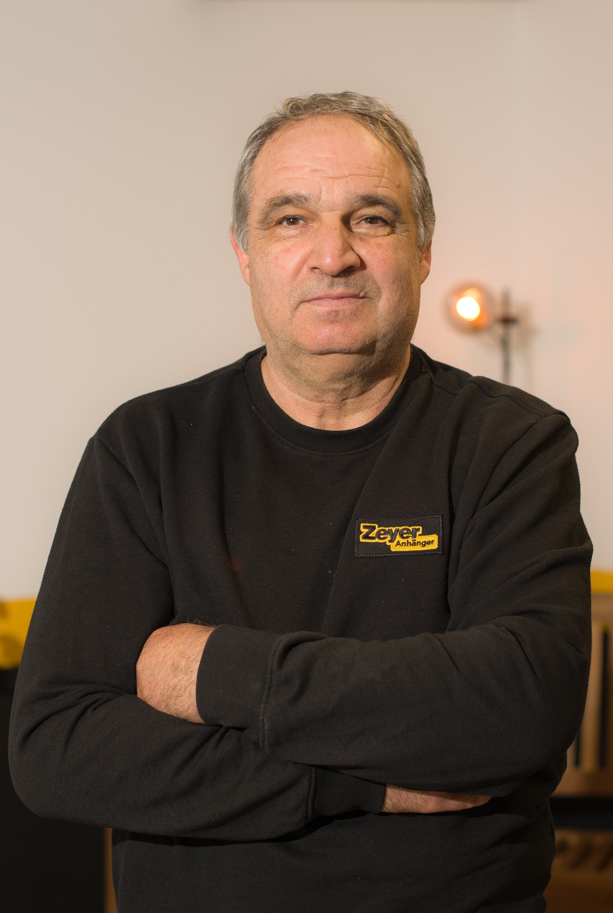 Mann mit schwarzem Pullover, verschränkte Arme